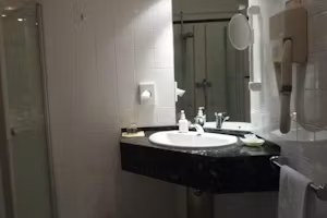 Badezimmer des Komfortzimmers mit Dusche und Waschtisch