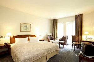 Komfortzimmer mit Doppelbett und Sitzecke am Fenster